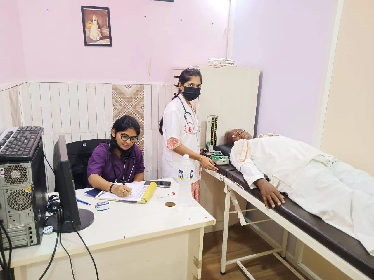 Care workers with an older man in an examination room