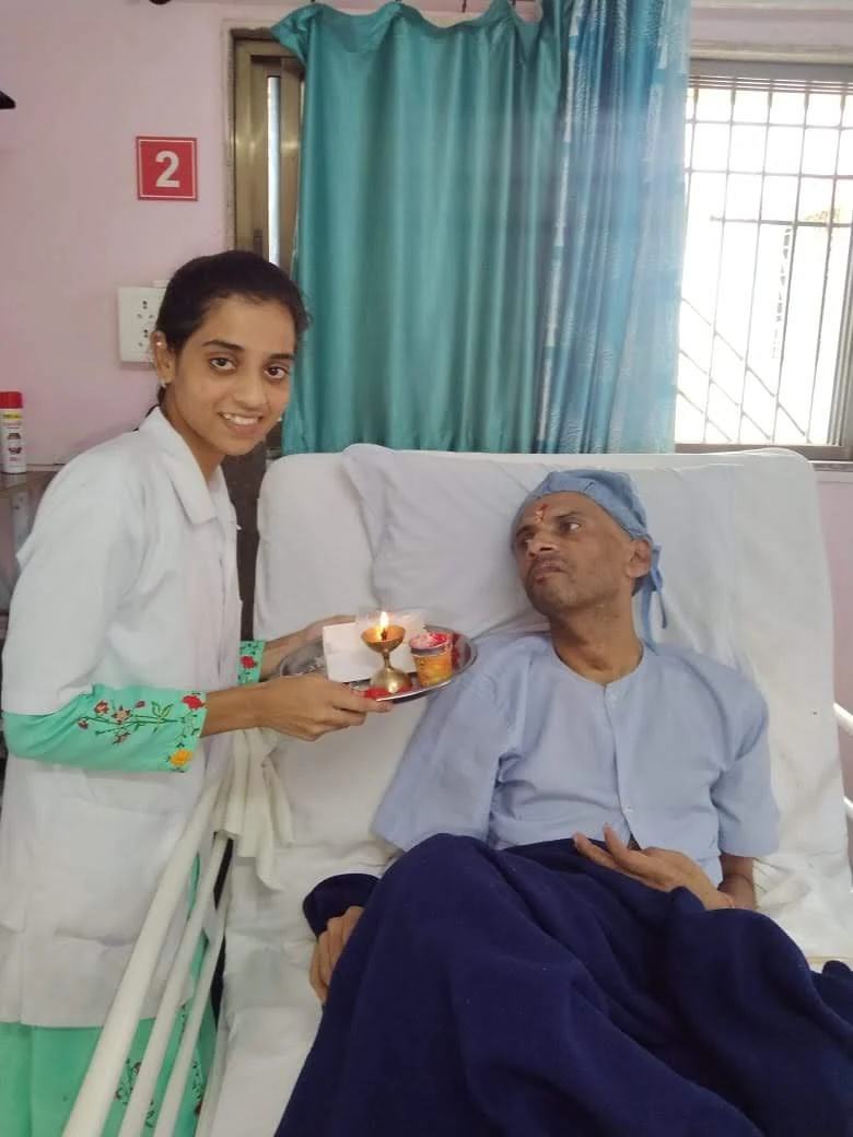 A care worker beside a patient at the centre during a small ceremonial moment