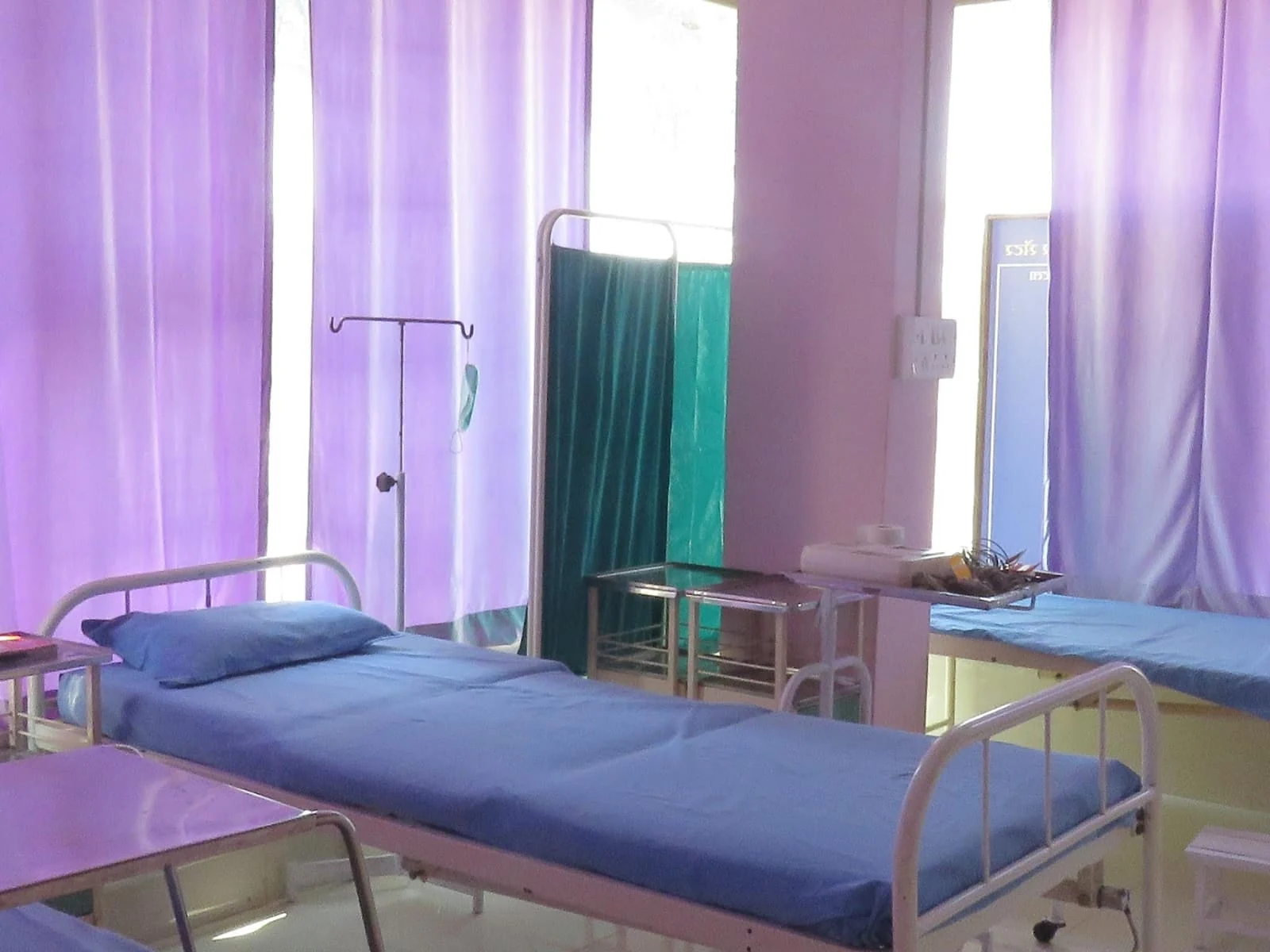 Unoccupied care beds beside privacy curtains at the centre
