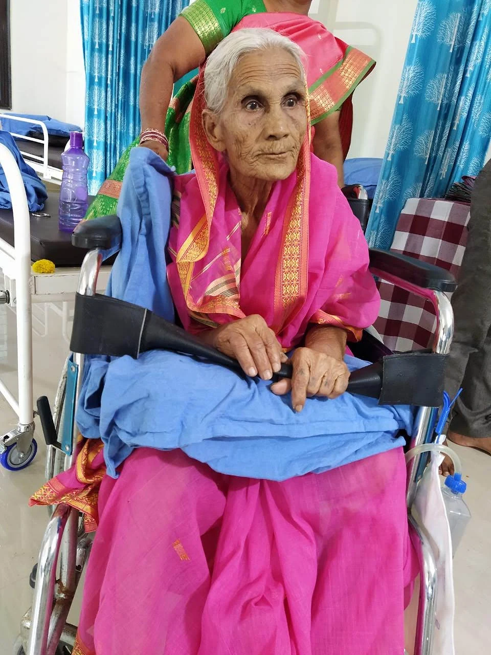 An older woman in a pink sari sitting in a wheelchair at Jeevan Jyoti