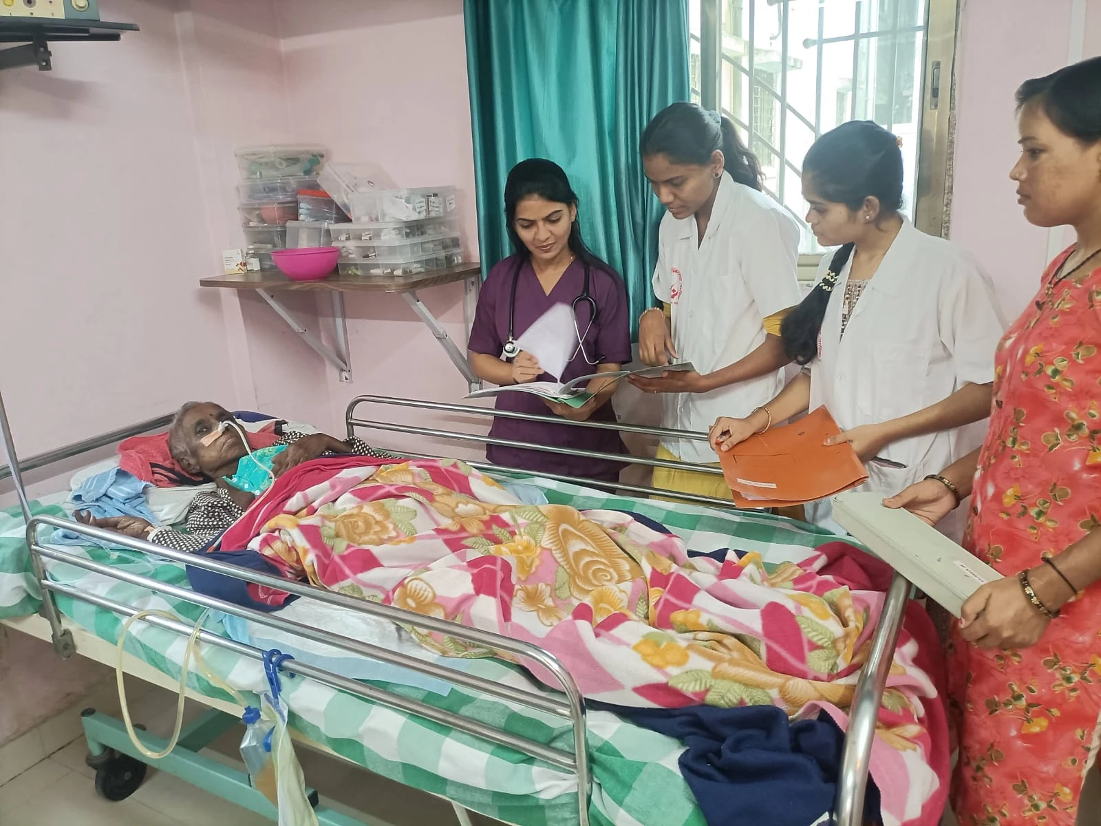 Several people reviewing a file beside a patient at Jeevan Jyoti